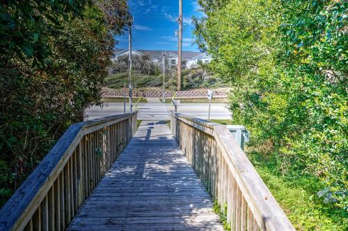 a wooden bridge over a road with trees at Hotel Alice in Atlantic Beach