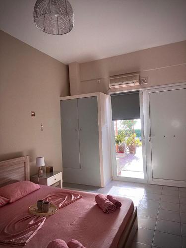 a bedroom with a bed and a large sliding glass door at Seaview Apartments in Anavissos