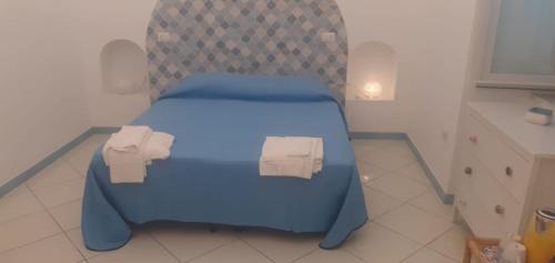Una cama azul en una cocina con dos rollos. en Residenze Azzurra, en Ponza