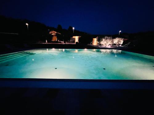 a large pool of blue water at night at B&B Alciliegio in Casnate con Bernate