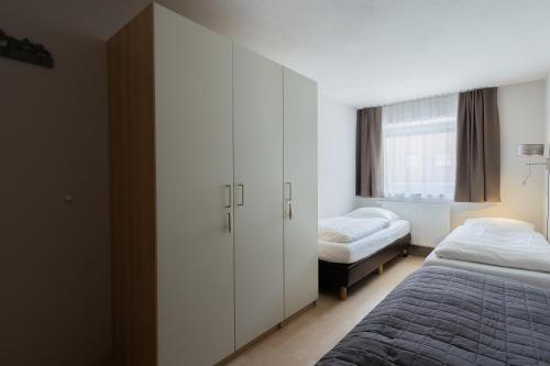 a bedroom with white cabinets and a bed and a window at Haus Almkreek in Kaprun