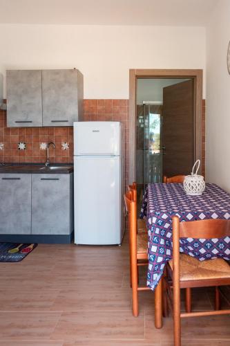 a kitchen with a table and a white refrigerator at Tenuta San Lorenzo in Otranto