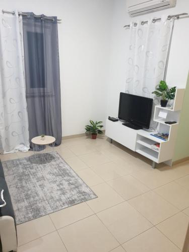 - un salon avec une télévision sur un meuble blanc dans l'établissement Sophos, à Supetar