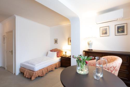 a bedroom with a bed and a table and chairs at Hotel Castel Rundegg (Adults Only) in Merano
