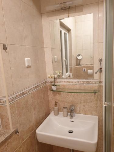 un baño con lavabo y espejo en Sophos, en Supetar