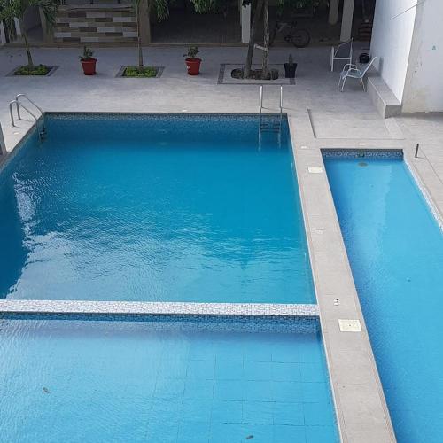 a large blue swimming pool next to a building at Preciosa Suite Familiar Dep-31 in Playas