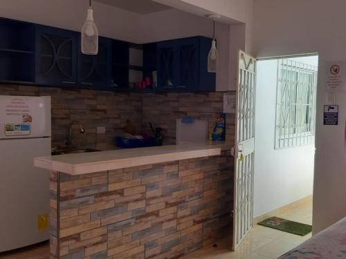 a kitchen with blue cabinets and a brick wall at Preciosa Suite Familiar Dep-31 in Playas