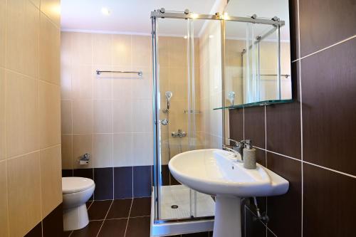 a bathroom with a sink and a shower with a toilet at Nadia's Studios & Apartments in Argasi, Sea-View in Argasi