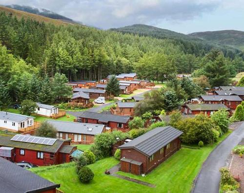 eine kleine Stadt mit Häusern und Bäumen und einer Straße in der Unterkunft Corrie Lodge, Glendevon in Glendevon