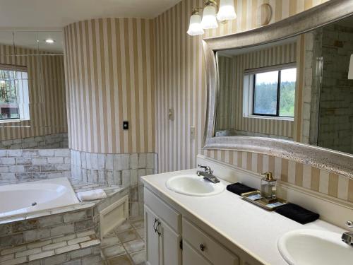 a bathroom with two sinks and a tub and a mirror at Old Alcohol Plant in Port Hadlock
