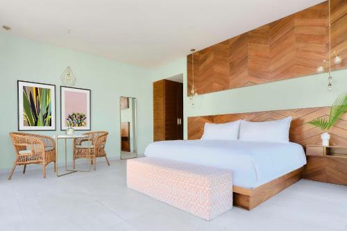 a bedroom with a large bed and a table at CALIXTA Hotel in Playa del Carmen