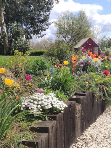 a garden with colorful flowers and a wooden fence at Gîte L'évidence in Saint-Caradec-Trégomel