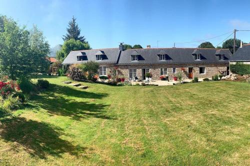 a large brick house with a large yard at Gîte L'évidence in Saint-Caradec-Trégomel