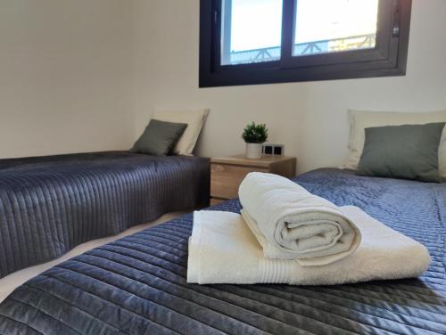 a bedroom with two beds with towels on them at SUNSET WAVES blue sky apartment in Benidorm