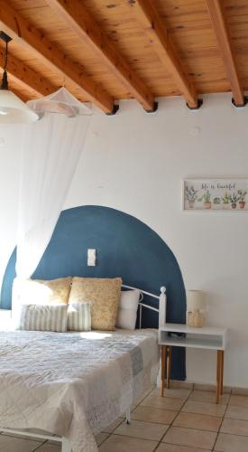 a bedroom with a bed with a blue head board at Akti Posidonos in Elounda