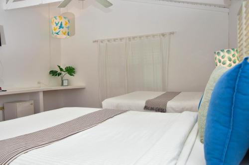 two beds in a room with white walls at Casa Grande Hotel Restaurant in Las Terrenas