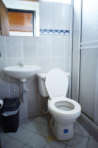 a bathroom with a toilet and a sink at Hotel Descanso Inn Villavicencio in Villavicencio