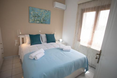 Un dormitorio con una cama azul con toallas. en Mel Studio 2 (kalamaki), en Kalamaki