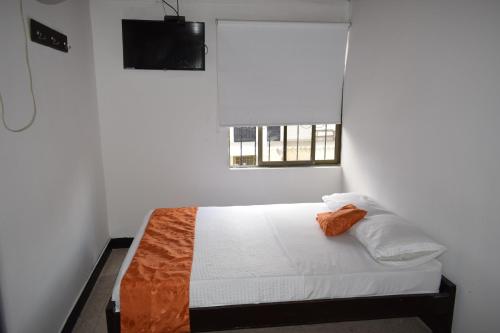 a white room with a bed with a window at Hotel Descanso Inn Villavicencio in Villavicencio