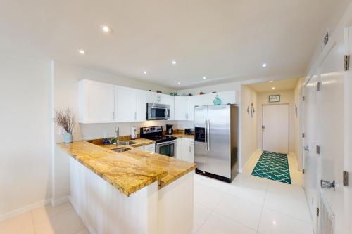 a kitchen with white cabinets and a granite counter top at Solare Garden Villa 877 in South Padre Island