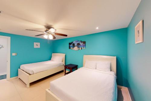 a bedroom with blue walls and a bed and a chair at Solare Garden Villa 877 in South Padre Island