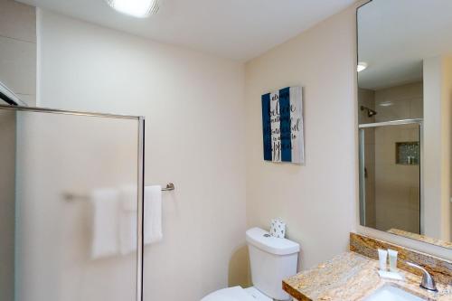 a bathroom with a toilet and a sink and a mirror at Solare Garden Villa 877 in South Padre Island