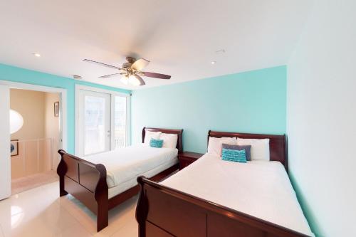 a bedroom with two beds and a ceiling fan at Solare Garden Villa 877 in South Padre Island