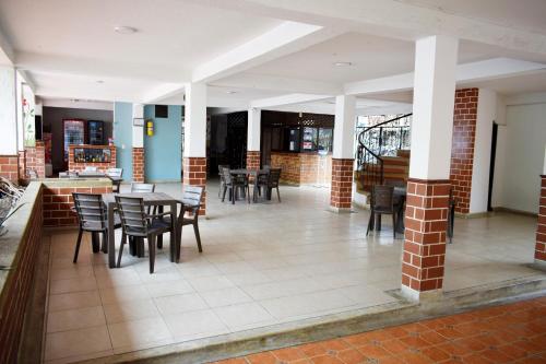 a dining room with tables and chairs in a building at Hotel Descanso Inn Villavicencio in Villavicencio
