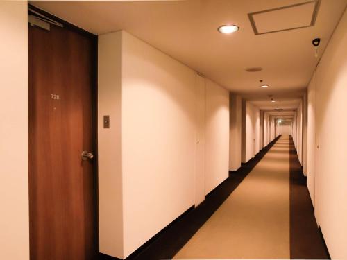 a long corridor with white walls and a long hallway at Hotel Royal Morioka in Morioka