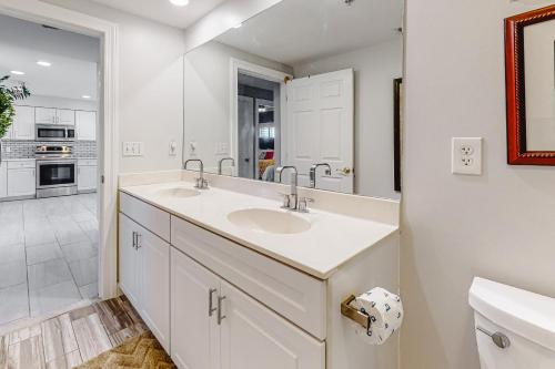 a bathroom with two sinks and a large mirror at Ocean's Edge 302 in Ocean City