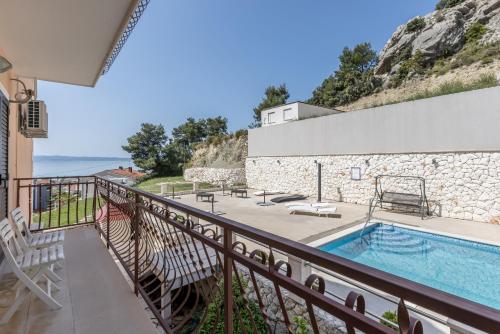 a house with a swimming pool and a balcony at Bed & Breakfast Senator in Podstrana