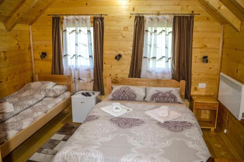 莫伊科瓦茨的住宿－Tara Valley Eco Lounge，小木屋内一间卧室,配有两张床