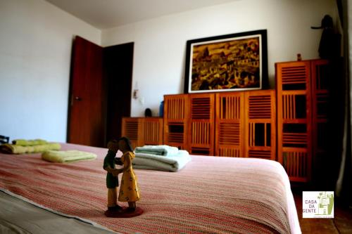 two dolls standing on a bed in a bedroom at Casa da Gente in Rio de Janeiro