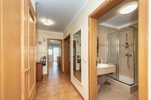 uma casa de banho com um chuveiro, um lavatório e um espelho. em The Canadians Escape ~ Relaxing Portimão Portugal em Portimão