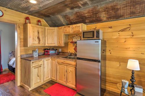 a kitchen with wooden cabinets and a stainless steel refrigerator at Rustic Norfork Studio with Million Dollar View! in Norfork