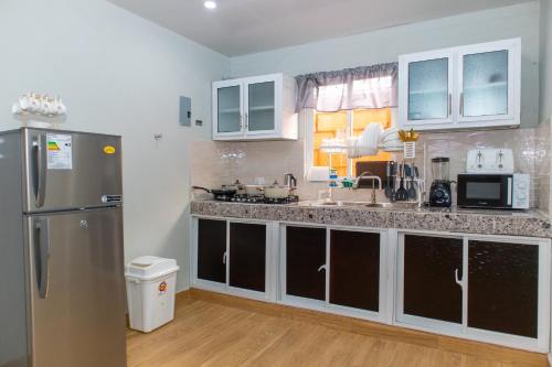 a kitchen with a stainless steel refrigerator and a window at Villa confortable para 7 personas in Pedernales