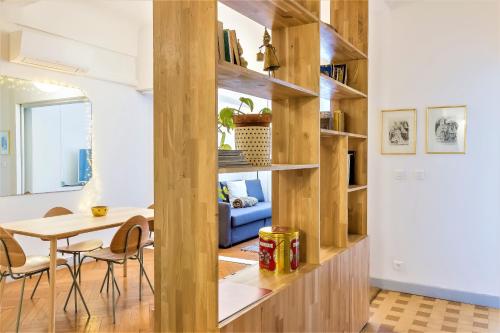 - un salon avec des étagères en bois et une table dans l'établissement L'IMPERIA loft by Booking Guys, à Nice