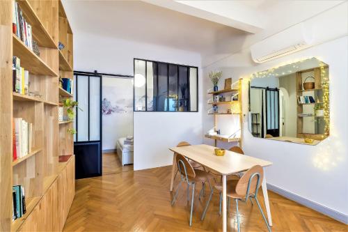 une salle à manger avec une table, des chaises et un miroir dans l'établissement L'IMPERIA loft by Booking Guys, à Nice