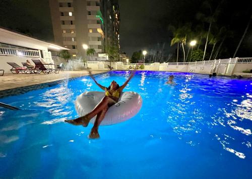 a woman is in a swimming pool in an inflatable at Beachfront Tropical Tantra Apartment in San Juan