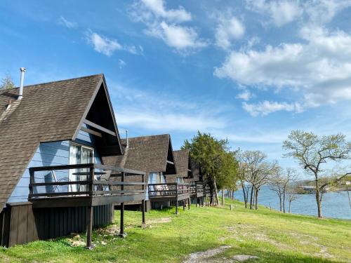 a row of cottages on the shore of a lake at Calm Waters Resort in Branson