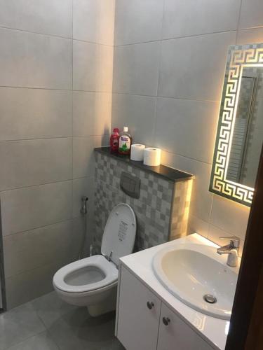 a bathroom with a white toilet and a sink at New and cosy apartment in Amman (Al Weibdeh) in Amman