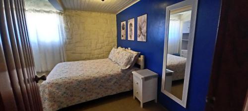 a blue bedroom with a bed and a mirror at Recanto do Sonho em Campos do Jordão in Campos do Jordão