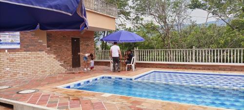 a man and a child standing under an umbrella next to a pool at BONANZA in Monterrey