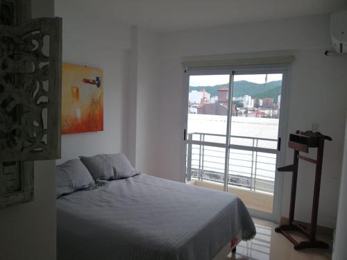 - une chambre avec un lit et une grande fenêtre dans l'établissement El Descanso, à Salta