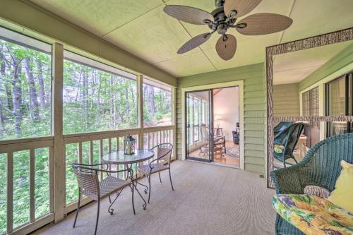 a screened porch with a table and chairs and a ceiling fan at Scenic Sapphire Condo with Deck and Gas Grill! in Sapphire