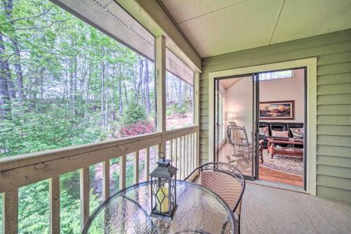 a screened in porch with a glass table and chairs at Scenic Sapphire Condo with Deck and Gas Grill! in Sapphire