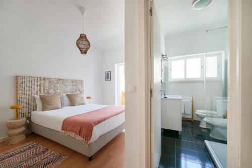 a bedroom with a bed and a bathroom at Sunset Balcony Apartment, By TimeCooler in Lisbon