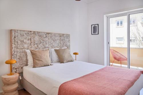een slaapkamer met een groot bed en een bakstenen muur bij Sunset Balcony Apartment, By TimeCooler in Lissabon