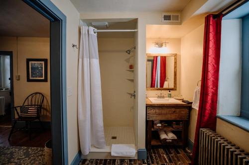 a bathroom with a white shower curtain and a sink at Galvanized America Inn & Art Gallery in Doylestown
