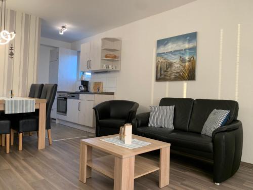 - un salon avec un canapé et une table dans l'établissement Kleine Brise Apartment 12 Kapitäns-Kajüte, à Büsum